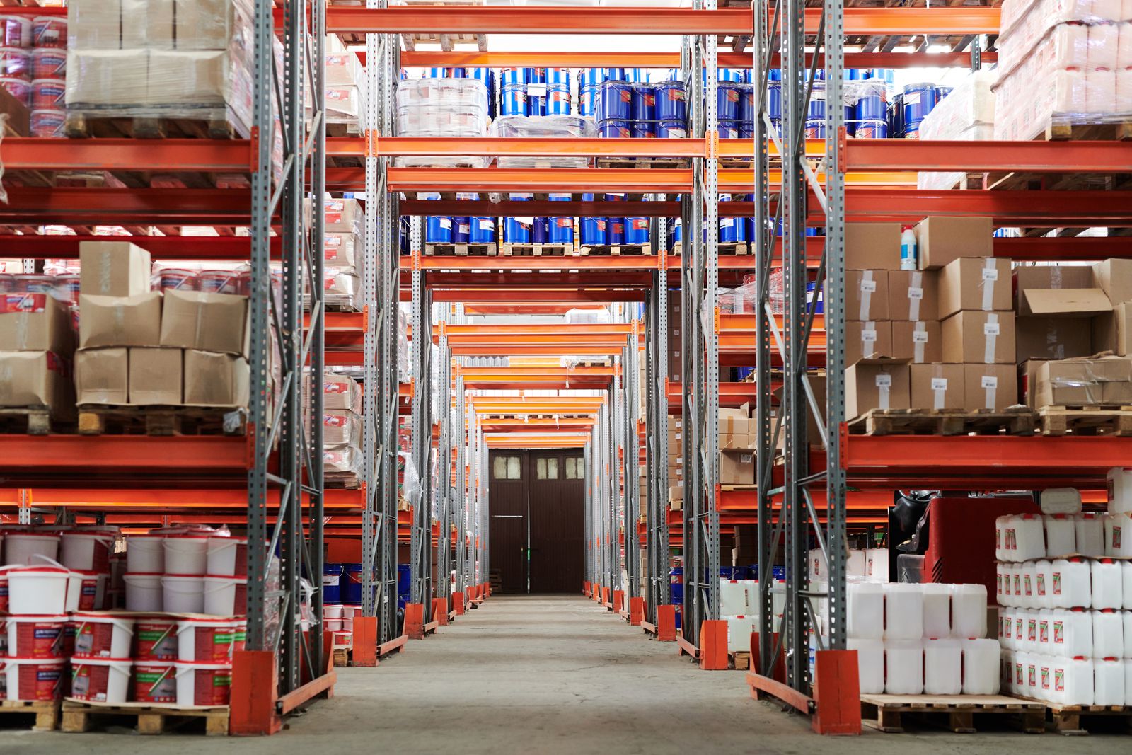 Wide view down a warehouse aisle with tall storage racks and palletised goods